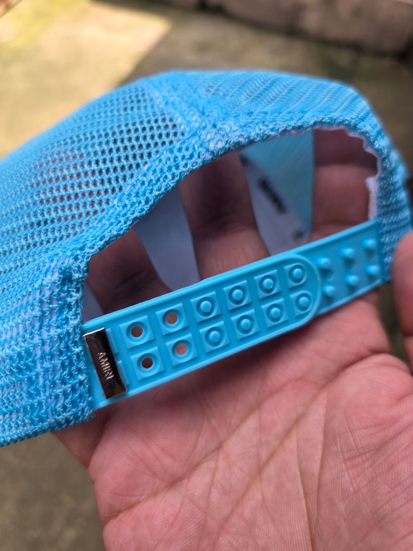 AMIRI Pegasus Blue Trucker Cap (Category: Caps & Hats) located in Santa Maria. Submitted by purefalcon-f7cf (Listing ID 1464276953, Image 3). Description: - Light blue AMIRI trucker cap - Features embroidered text: 'AMIRI ENGINEERED 2023 LOS ANGELES CALIFORNIA DREAMERS' - Breathable mesh back - Adjustable snap closure for a custom fit - Made in USA - Materials sourced from Italy - Composition: 98% Cotton, 2% Elastane.