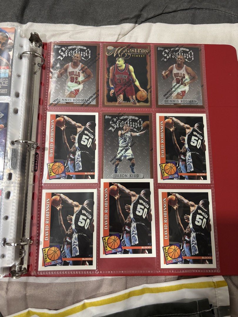 Assorted characters (Category: Raw Singles) located in Santa Rosa. Submitted by kcp2025 (Listing ID 1464327868, Image 3). Description: - Binder full of NBA basketball cards - Features stars: Dennis Rodman, David Robinson, Jason Kidd, Grant Hill, Tim Hardaway, and more - Ideal for any basketball fan or collector - Red binder labeled 'NBA PLAYERS' - All cards are in protective sleeves.
