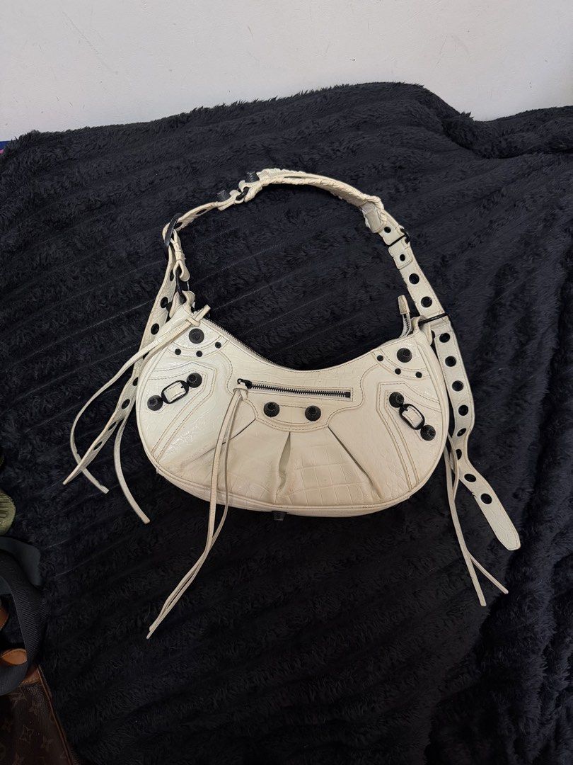Balenciaga White Leather Hobo Bag (Category: Luxury Bags & Wallets) located in Paranaque City. Submitted by glendalecollection (Listing ID 1464200940, Image 1). Description: Genuine white leather Balenciaga hobo bag -Coded - Under zip BB - Textured leather finish - Silver hardware details - Zipper closure - Adjustable strap - Ideal for everyday use.