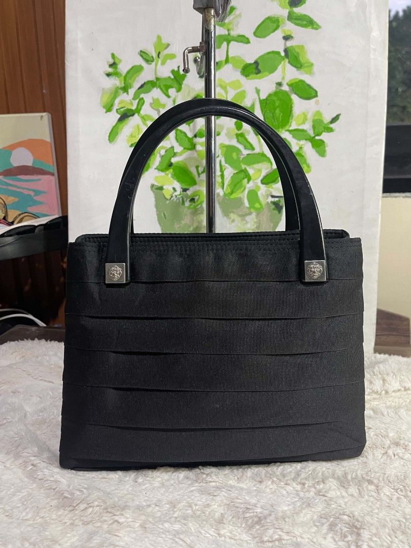 Black Fabric Handbag with Glossy Handles (Category: Tote Bags) located in Naawan. Submitted by twilly.apparel2 (Listing ID 1464222551, Image 1). Description: - Classic black fabric handbag - Unique textured ribbon design on the front - Two glossy black handles - Multiple zippered compartments inside for organization - Versatile for daily use or special occasions - Clean and simple design.