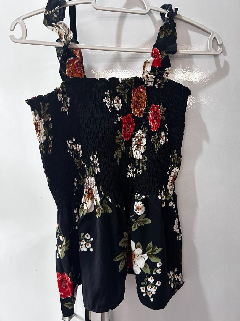 Black Floral Smocked Tie-Strap Top 🌸 (Category: Sleeveless) located in Pasig City. Submitted by ladyleslieisletavelarde4902 (Listing ID 1464140456, Image 1). Description: A sweet summer staple featuring a stretchy smocked bodice, tie-up ribbon shoulder straps, and a flirty peplum hem. Brand: Coco Cabaña Tag Size: M | / Best fits Small to Medium (due to stretchy smocked bodice) Purchase direct from store. MOP: Gcash / Bank Transfer Delivery: SF s