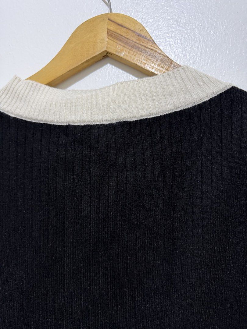 Black V-Neck Button-Up Knit Vest (Category: Sleeveless) located in Caloocan City. Submitted by ashpreloves (Listing ID 1464201887, Image 3). Description: - Cute black knit vest - Cream trim detail - V-neckline - Button-up front - Ribbed hem and collar - Perfect for layering over shirts or dresses - Ideal for preppy or casual outfits.