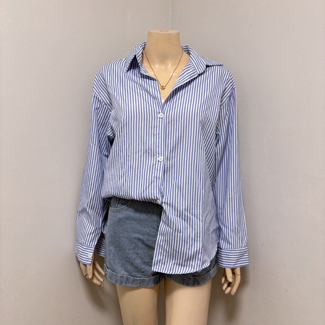 Blue Stripes Longsleeves Buttondown Polo (Category: Shirts) located in Imus. Submitted by reloved.nd (Listing ID 1464261050, Image 1). Description: - Classic blue and white striped button-up shirt - Long sleeves with button cuffs - Versatile: looks great tucked into shorts or worn open over a tank top - Easy to style for casual or slightly dressed-up occasions.