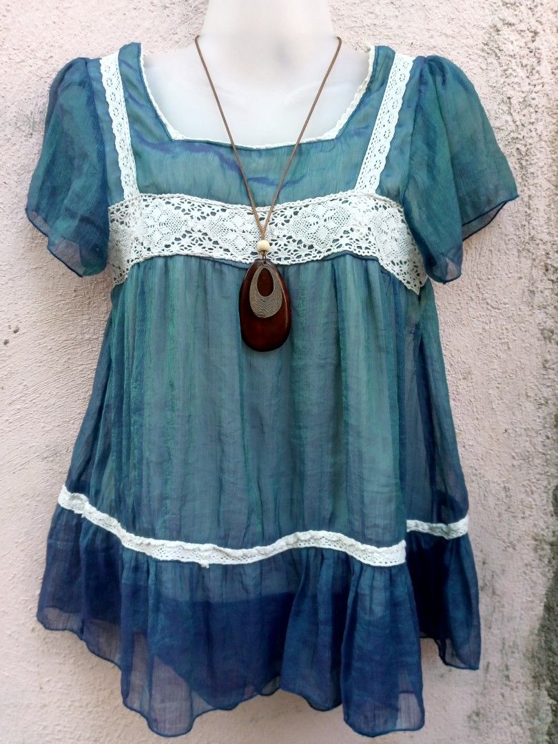 Boho blue laced top (Category: Dresses) located in Placer. Submitted by whimsythrifts (Listing ID 1464214480, Image 1). Description: - Flowy tunic dress - Beautiful blue-green ombre color - Delicate white lace trim on neckline, empire waist, and hem - Short, fluttery sleeves - Comes with a unique wooden pendant necklace - Perfect for a bohemian or casual look.