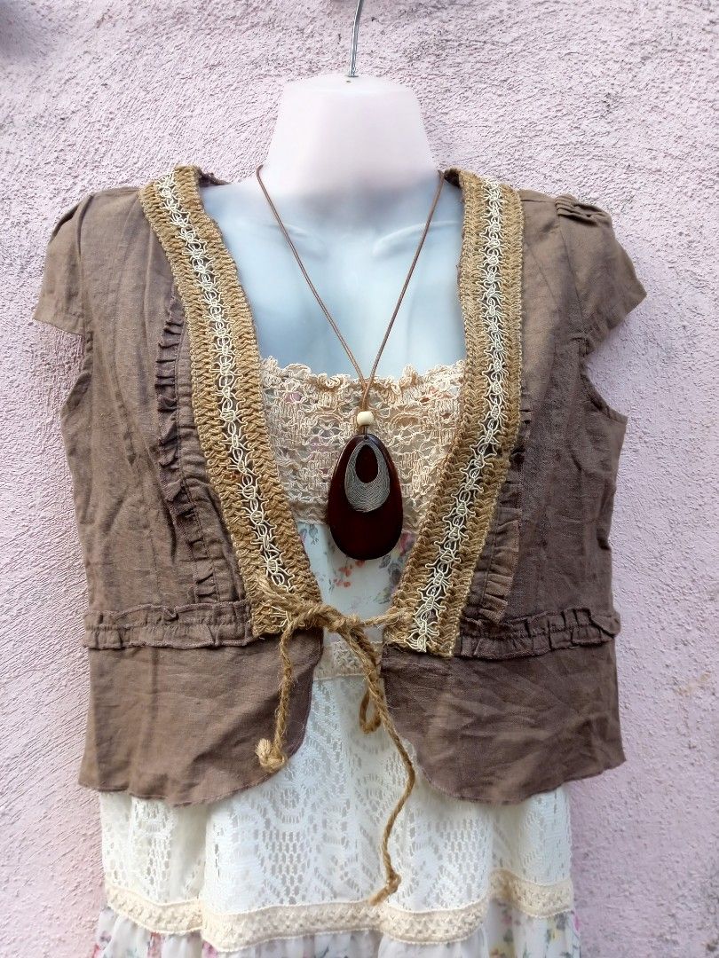 Boho Crochet Trimmed Vest (Category: Dresses) located in Placer. Submitted by whimsythrifts (Listing ID 1464190935, Image 1). Description: - Cute boho-inspired outfit - Brown vest with crochet trim and ruffled details - Vest features short sleeves and front ties - Layered over a white floral and lace dress - Ideal for a relaxed, stylish look - Necklace shown is not included +sf.