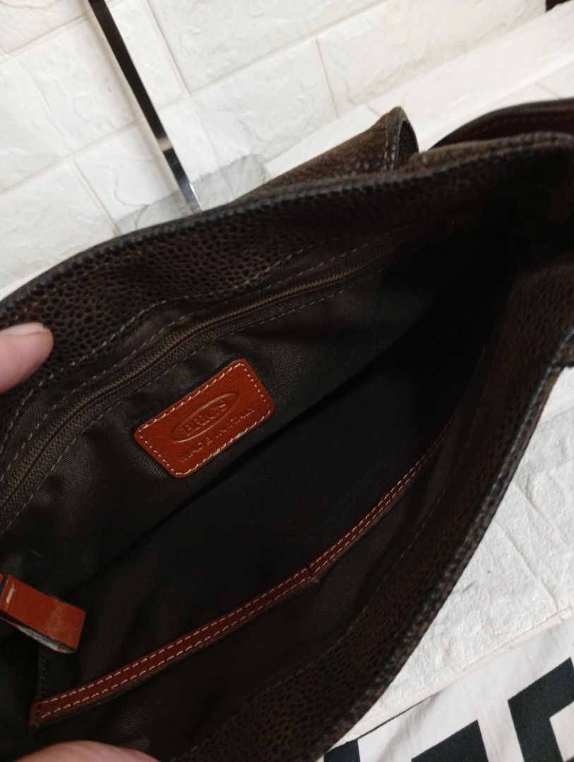 BRIC'S Classic Leather Crossbody Bag (Category: Cross-body Bags) located in Las Pinas. Submitted by etoksi1234 (Listing ID 1464202626, Image 3). Description: Pre-loved Bric's classic crossbody bag featuring a textured dark brown finish accented by contrasting tan leather trim and a distinctive front buckle closure. Made in Italy. Size: L-12" x H-8" x D-3.5".