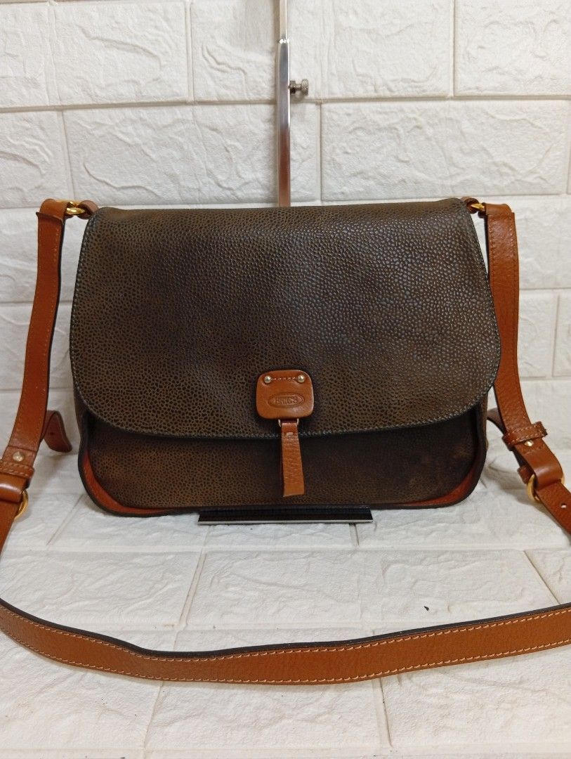 BRIC'S Classic Leather Crossbody Bag (Category: Cross-body Bags) located in Las Pinas. Submitted by etoksi1234 (Listing ID 1464202626, Image 1). Description: Pre-loved Bric's classic crossbody bag featuring a textured dark brown finish accented by contrasting tan leather trim and a distinctive front buckle closure. Made in Italy. Size: L-12" x H-8" x D-3.5".