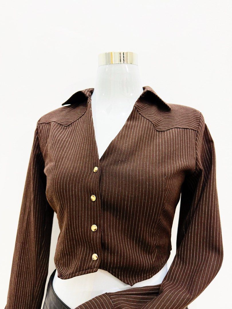Brown Cropped Button-Up Shirt (Category: Shirts) located in Manila. Submitted by e.louise (Listing ID 1464332950, Image 3). Description: - Stylish brown long-sleeve shirt - Features crisp white pinstripes - Trendy cropped length - Classic button-up front - Smart collar and pointed shoulder details - Estimated size: Small to Medium - Perfect for dressing up or down.