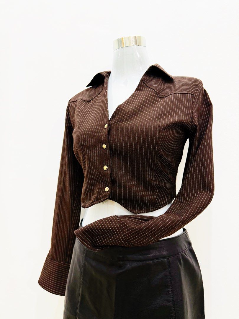 Brown Cropped Button-Up Shirt (Category: Shirts) located in Manila. Submitted by e.louise (Listing ID 1464332950, Image 2). Description: - Stylish brown long-sleeve shirt - Features crisp white pinstripes - Trendy cropped length - Classic button-up front - Smart collar and pointed shoulder details - Estimated size: Small to Medium - Perfect for dressing up or down.