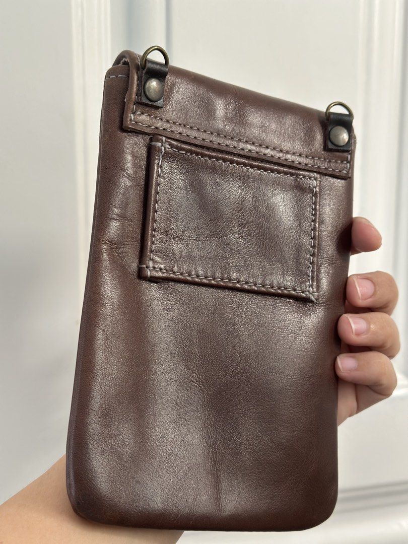 Brown Leather Pouch with Belt Loop and Card Slots (Category: Luxury Bags & Wallets) located in Batangas. Submitted by enyahsnivl56498 (Listing ID 1464189942, Image 2). Description: - Brown leather pouch - Belt loop on the back for easy carrying - Interior slots - Secure velcro strap closure - Perfect for keeping small essentials accessible - Phone pouch - Approximate dimensions: 6 inches tall x 3.5 inches wide Kasya ang PROMAX na iphone .
