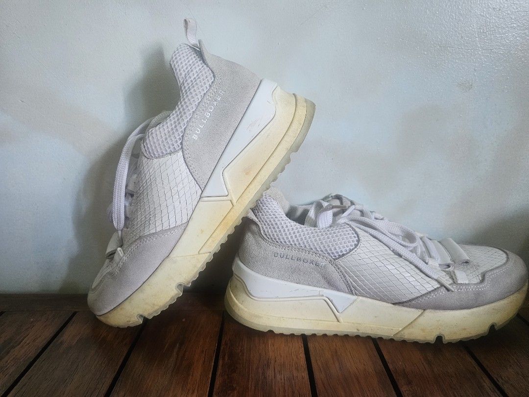 Bullboxer White/Grey Sneakers (Category: Sneakers) located in Lupao. Submitted by selahthriftedclothing (Listing ID 1464271009, Image 1). Description: - White and grey Bullboxer sneakers - Suede and textured material for a unique look - Chunky sole for a trendy vibe - Lace-up closure for a secure fit - Soles have slight yellowing due to normal wear - Ideal for everyday casual wear.