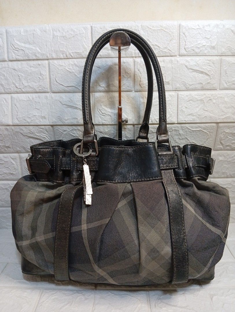 Burberry Nova Check Leather Trim Tote Bag (Category: Shoulder Bags) located in Las Pinas. Submitted by etoksi1234 (Listing ID 1464199750, Image 1). Description: Pre-loved Burberry Shimmer Nova Check Tote Bag, featuring dark metallic distressed leather trim and a distinctive buckled strap detail. .