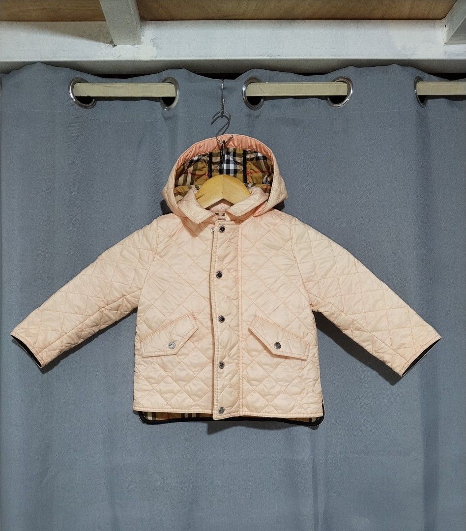 Burberry Quilted Hooded Jacket Pink Nova Check Lining (Category: Babies & Kids Fashion) located in Pasig City. Submitted by loveforlux_2025 (Listing ID 1464341590, Image 1). Description: - Adorable pink quilted jacket for kids - Features iconic Burberry Nova Check lining inside and on the hood - Zip closure with snap button overlay - Two functional front pockets - Ideal for keeping warm in cooler weather.