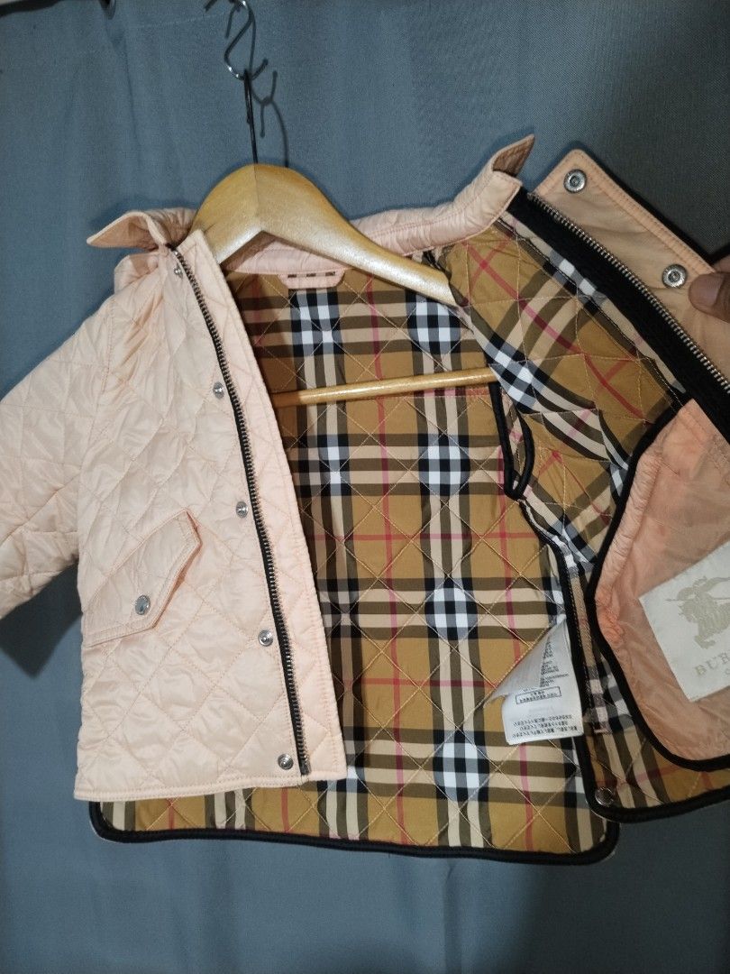 Burberry Quilted Hooded Jacket Pink Nova Check Lining (Category: Babies & Kids Fashion) located in Pasig City. Submitted by loveforlux_2025 (Listing ID 1464341590, Image 3). Description: - Adorable pink quilted jacket for kids - Features iconic Burberry Nova Check lining inside and on the hood - Zip closure with snap button overlay - Two functional front pockets - Ideal for keeping warm in cooler weather.