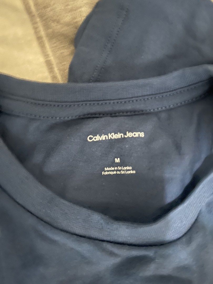 Calvin Klein crew neck shirt (Category: Shirts) located in Paranaque City. Submitted by ekkostarfall.12902 (Listing ID 1464213994, Image 3). Description: - Navy blue - Iconic CK logo graphic with repeating Calvin Klein text across the chest - Crew neck, short sleeves - Size Medium - Brand New with tag MOP: Maya, Bank transfer SF shouldered by buyer Parañaque .