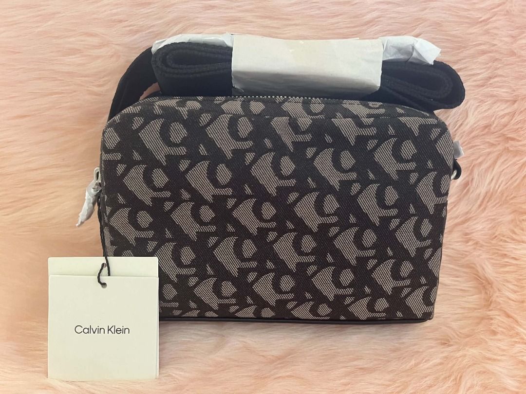 Calvin Klein Monogram Camera Bag (Brown) (Category: Cross-body Bags) located in Nabua. Submitted by jjtampz192013 (Listing ID 1464184143, Image 1). Description: Calvin Klein Monogram Camera Bag - Brown New Arrival from CANADA � Authentic Calvin Klein � Adjustable strap � Lightweight & perfect for everyday use .