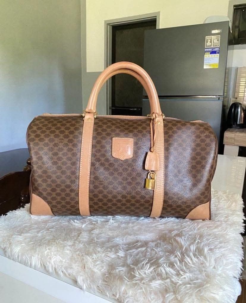 Celine Macadam Monogram Canvas Leather Trimmed Duffle Bag (Category: Luxury Bags & Wallets) located in Manila. Submitted by rufus_apparel (Listing ID 1464299850, Image 2). Description: - Iconic Celine Macadam print duffle bag - Color: Brown canvas with tan leather trim and handles - Features original lock and keys - Equipped with a Swiss-made zipper - Interior shows some signs of wear but is clean - Ideal for weekend getaways or as a carry-on lug
