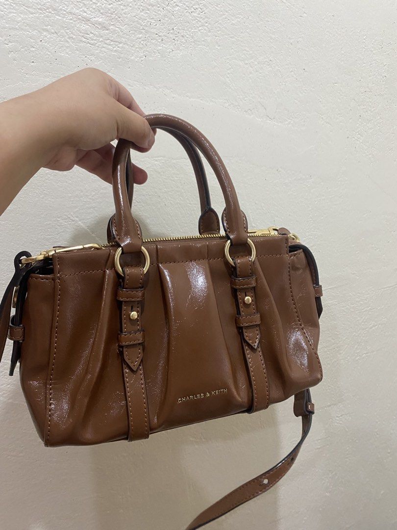 Charles & Keith Britton Top Handle Tote Bag ✨ (Category: Cross-body Bags) located in Manila. Submitted by preloved.thengsss (Listing ID 1464330973, Image 2). Description: Add a touch of polished elegance to your daily outfit with the Charles & Keith Britton Top Handle Tote Bag ✨ Details: Brand: Charles & Keith Model: Britton Top Handle Tote Bag Color: Warm Chestnut / Cognac Brown. Style: Pleated ruched detailing with stylish metallic ring charm a