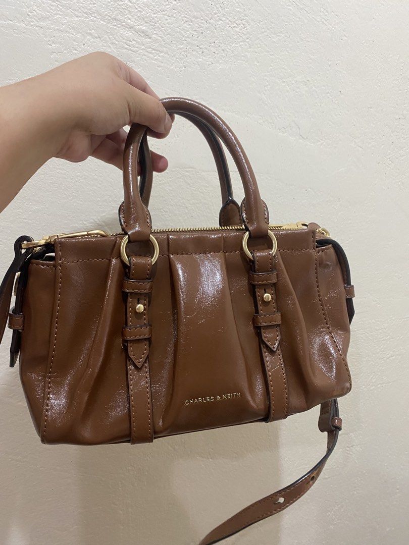 Charles & Keith Britton Top Handle Tote Bag ✨ (Category: Cross-body Bags) located in Manila. Submitted by preloved.thengsss (Listing ID 1464330973, Image 3). Description: Add a touch of polished elegance to your daily outfit with the Charles & Keith Britton Top Handle Tote Bag ✨ Details: Brand: Charles & Keith Model: Britton Top Handle Tote Bag Color: Warm Chestnut / Cognac Brown. Style: Pleated ruched detailing with stylish metallic ring charm a
