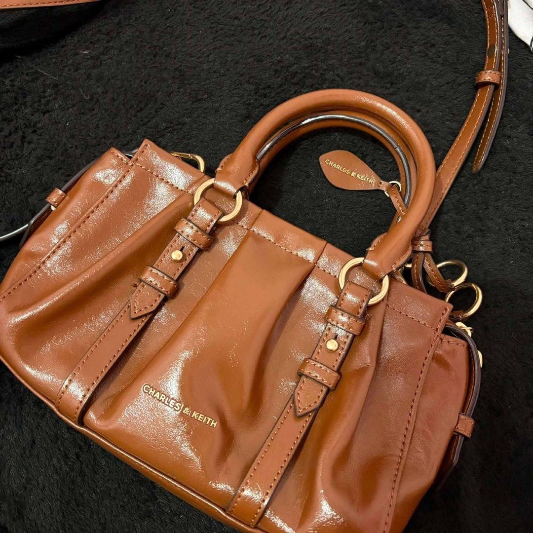 Charles & Keith Britton Top Handle Tote Bag ✨ (Category: Cross-body Bags) located in Manila. Submitted by preloved.thengsss (Listing ID 1464330973, Image 1). Description: Add a touch of polished elegance to your daily outfit with the Charles & Keith Britton Top Handle Tote Bag ✨ Details: Brand: Charles & Keith Model: Britton Top Handle Tote Bag Color: Warm Chestnut / Cognac Brown. Style: Pleated ruched detailing with stylish metallic ring charm a