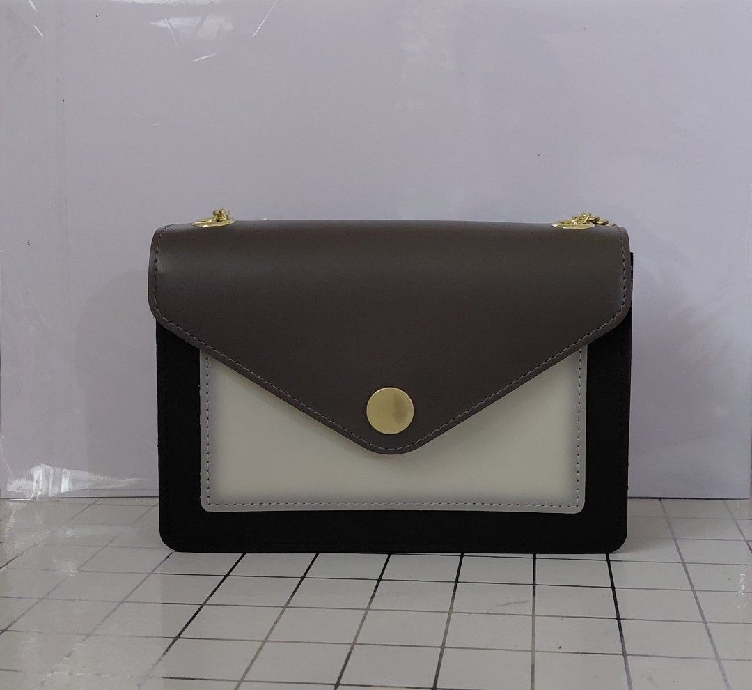 Chic Two-Tone Chain Crossbody Bag with Gold Hardware (Category: Cross-body Bags) located in Iligan City. Submitted by sophieyuh (Listing ID 1464191796, Image 2). Description: Cute crossbody bag. Dark grey and off-white color block design. Black suede-like material on the sides. Gold chain strap. Small gold button closure on the front flap. Great for nights out or casual wear. Fits essentials..