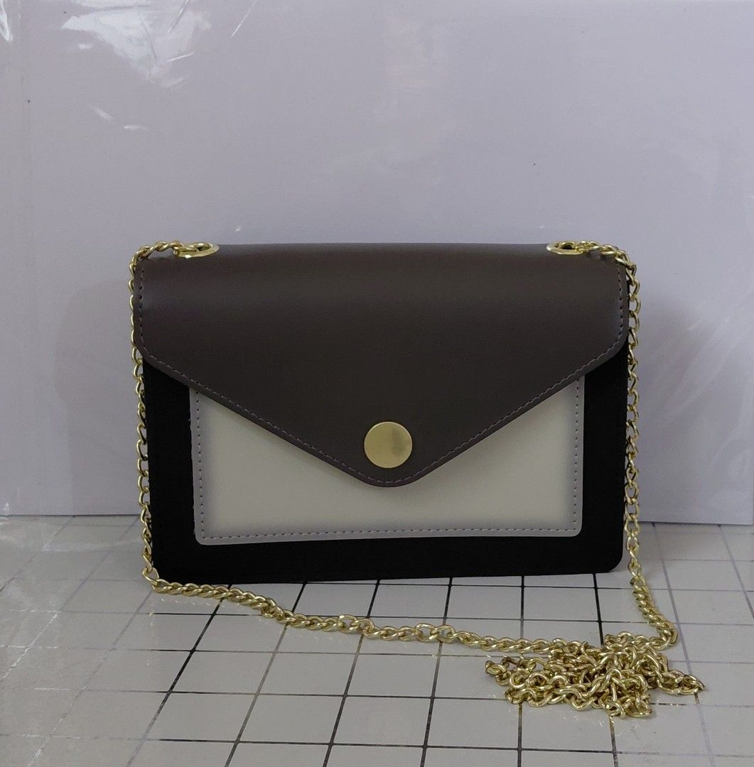 Chic Two-Tone Chain Crossbody Bag with Gold Hardware (Category: Cross-body Bags) located in Iligan City. Submitted by sophieyuh (Listing ID 1464191796, Image 1). Description: Cute crossbody bag. Dark grey and off-white color block design. Black suede-like material on the sides. Gold chain strap. Small gold button closure on the front flap. Great for nights out or casual wear. Fits essentials..