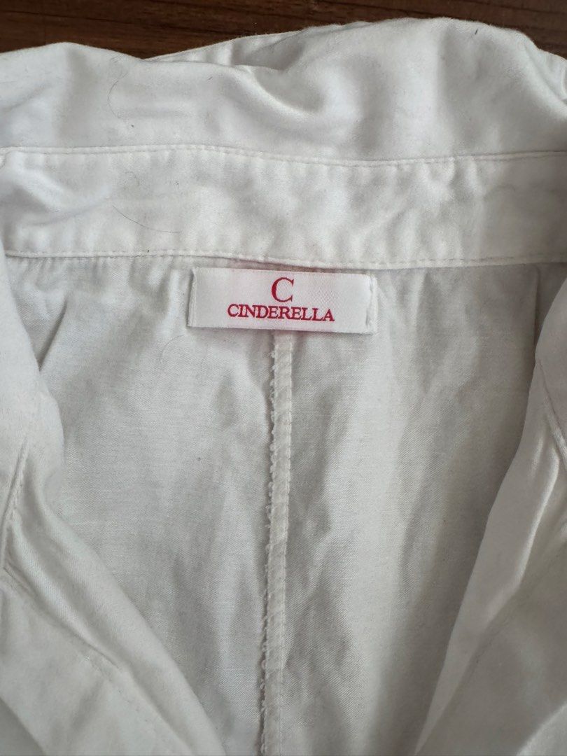 Cinderella White Button-Up Shirt (Category: Shirts) located in Rizal. Submitted by thrifty.mom (Listing ID 1464279706, Image 2). Description: - Brand: Cinderella - Color: White - Sleeve Length: Three-quarter sleeves with button tab for rolled cuffs - Pockets: Single chest pocket - Measurements: Pit to pit approx. 21 inches, Length approx. 25 inches - Style: Casual wear.