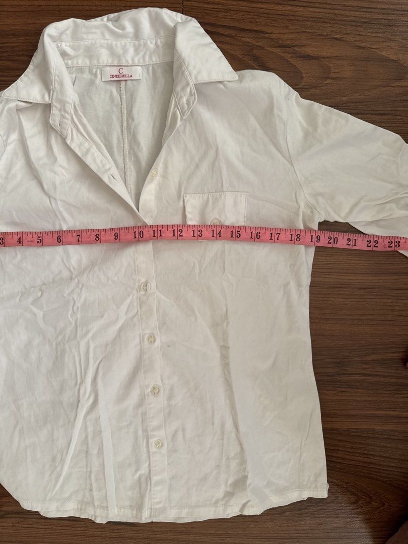 Cinderella White Button-Up Shirt (Category: Shirts) located in Rizal. Submitted by thrifty.mom (Listing ID 1464279706, Image 3). Description: - Brand: Cinderella - Color: White - Sleeve Length: Three-quarter sleeves with button tab for rolled cuffs - Pockets: Single chest pocket - Measurements: Pit to pit approx. 21 inches, Length approx. 25 inches - Style: Casual wear.