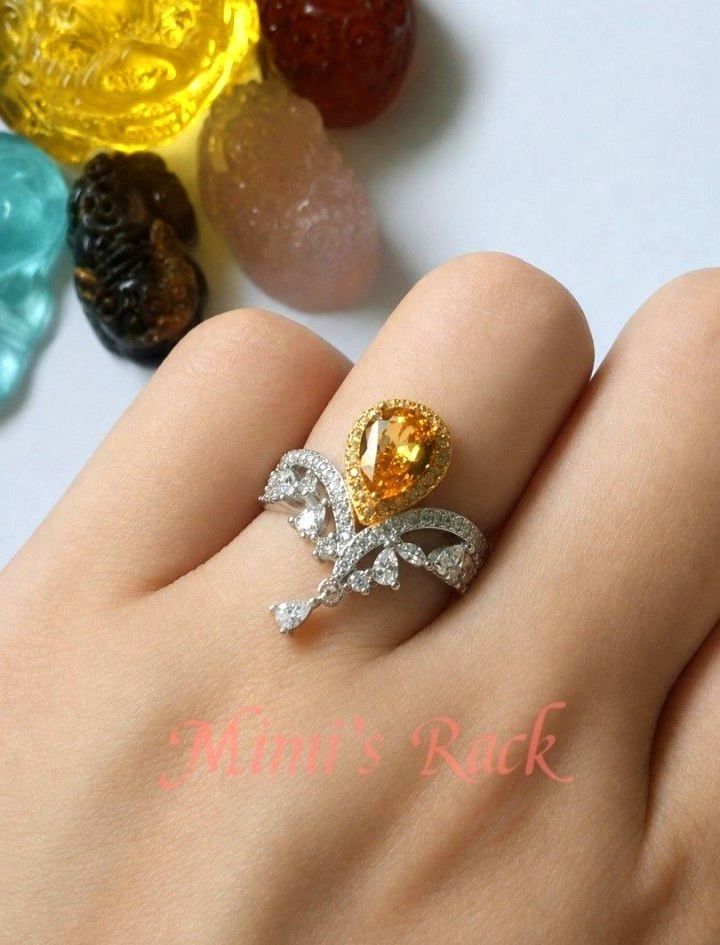 Citrine Pear Cut Adjustable Ring (Category: Rings) located in Taguig. Submitted by mimisrack (Listing ID 1464275378, Image 2). Description: 💛Add a touch of elegance with this stunning Citrine Pear Cut Adjustable Ring. Featuring a brilliant pear-shaped citrine centerpiece accented with sparkling clear stones and a delicate dangling crystal, this ring offers timeless beauty with a graceful, feminine design. ✨Citrine is known as the "Merchant's Sto