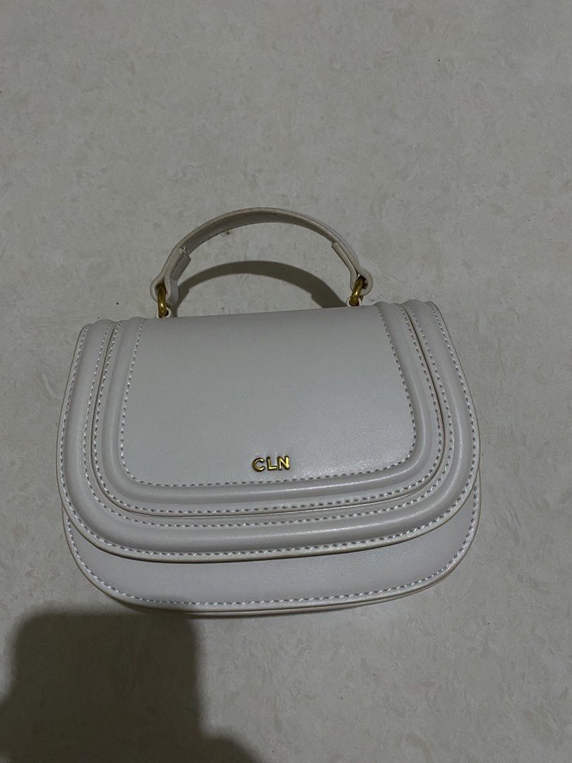 CLN White Handbag with Dust Bag (Category: Shoulder Bags) located in Taguig. Submitted by _lly.wyn (Listing ID 1464199097, Image 2). Description: - Brand new white CLN handbag - Comes with original dust bag and packaging - Features a gold CLN logo on the front - Strap is included inside the bag - Recently purchased.