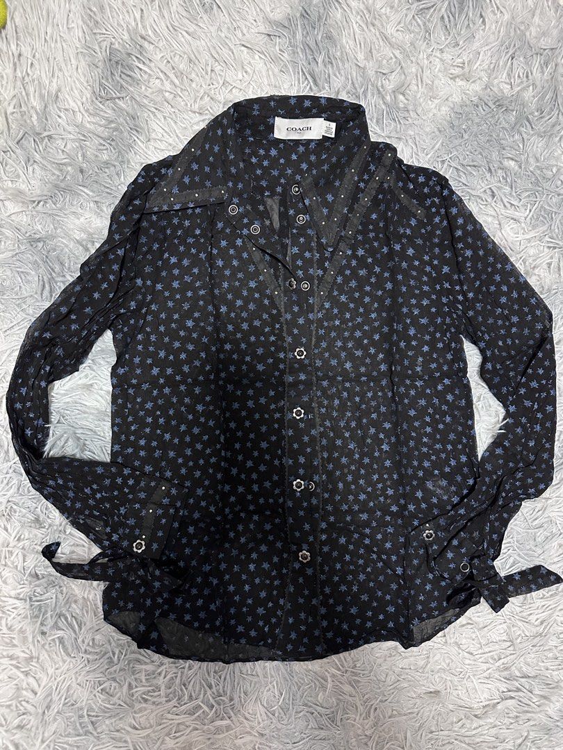 COACH 1941 Black Star Print Button-Up Shirt (Category: Shirts) located in Batangas. Submitted by kulilayfinds (Listing ID 1464220260, Image 1). Description: - COACH 1941 black long-sleeved shirt - Features a blue star print - Tie details at the cuffs - Button-up front closure - Subtle embellishments on collar and placket - Size: 0 - Made in China - Comes with a black inner wear.
