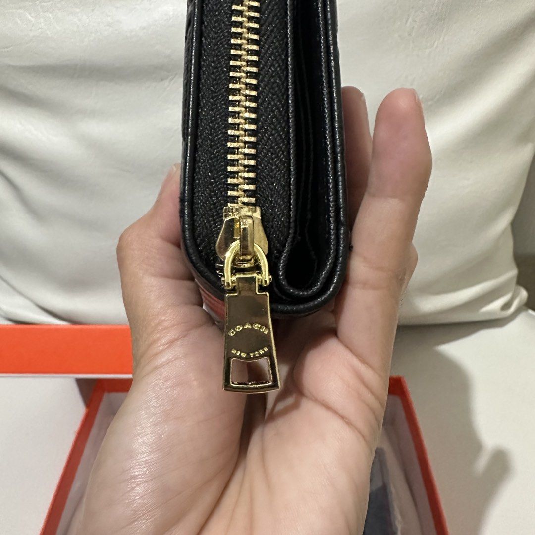 Coach Embossed Signature Wallet Black (Category: Wallets & Card holders) located in Marikina City. Submitted by bry_lei26 (Listing ID 1464181670, Image 3). Description: - Coach bi-fold wallet - Color: Black with all-over embossed signature C pattern - Hardware: Gold details - Closure: Snap closure with zip-around coin pocket - Interior: Card slots and clear ID window - Includes: Coach box - Origin: Made in Vietnam.