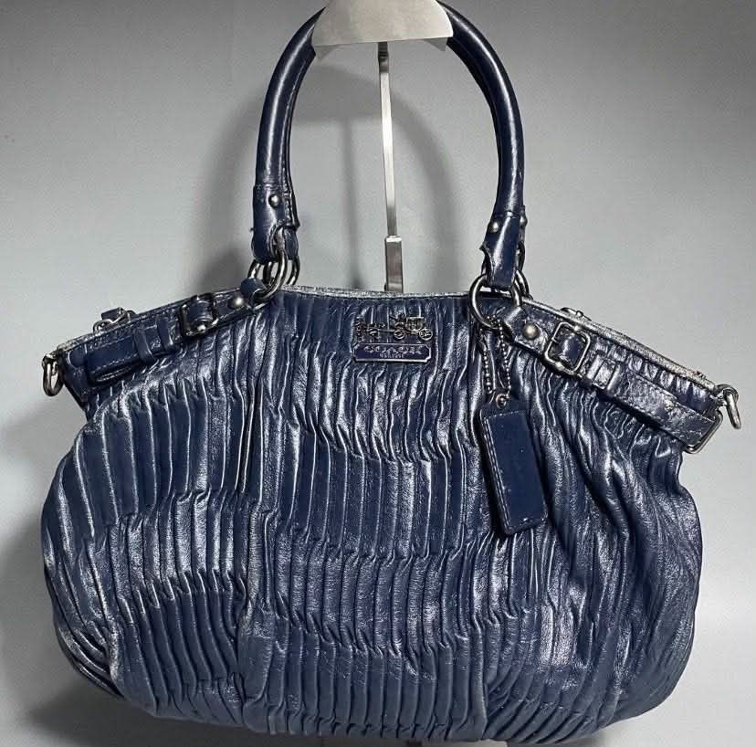 Coach Navy Blue Leather Ruched Shoulder Bag (Category: Luxury Bags & Wallets) located in Manila. Submitted by rufus_apparel (Listing ID 1464302583, Image 1). Description: - Navy blue Coach handbag - Made from soft, ruched leather - Silver hardware accents - Secure zipper closure - Interior fabric lining with serial number tag - Ideal everyday bag.