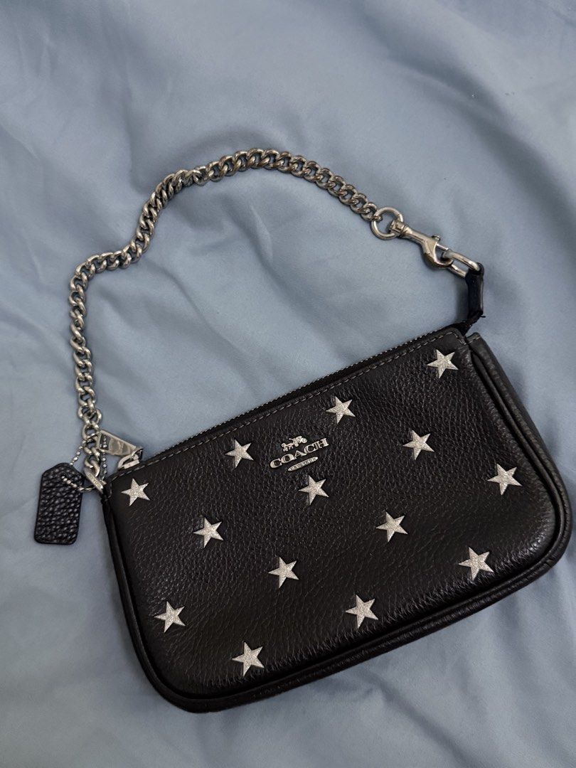 Coach Nolita (Category: Luxury Bags & Wallets) located in Taytay. Submitted by aleahrljr (Listing ID 1464231473, Image 1). Description: - Authentic Coach black leather wristlet - Fun all-over silver star print - Detachable silver chain strap - Includes matching leather fob - Secure zipper closure - Ideal for carrying your daily essentials.