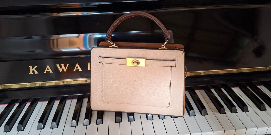 Coach Pebble Leather Top Handle Bag (Category: Luxury Bags & Wallets) located in Santa Rosa. Submitted by royyumireon27 (Listing ID 1464213467, Image 1). Description: - Light beige pebble leather handbag - Brown trim accents - Gold hardware closure on front flap - Top handles for comfortable carrying - Structured satchel style - Versatile for everyday or special occasions.