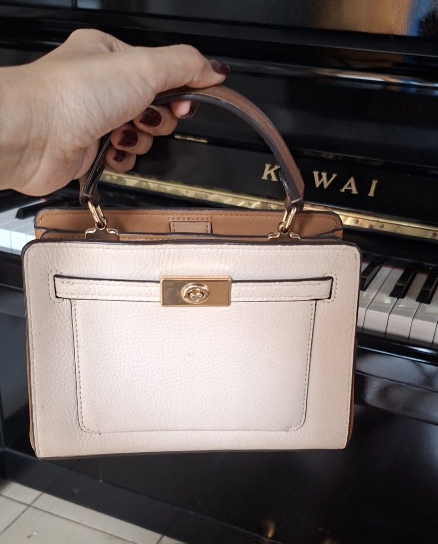 Coach Pebble Leather Top Handle Bag (Category: Luxury Bags & Wallets) located in Santa Rosa. Submitted by royyumireon27 (Listing ID 1464213467, Image 2). Description: - Light beige pebble leather handbag - Brown trim accents - Gold hardware closure on front flap - Top handles for comfortable carrying - Structured satchel style - Versatile for everyday or special occasions.