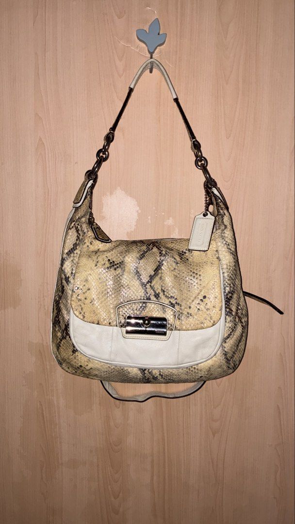 Coach Python Embossed Leather Hobo Shoulder Bag (Category: Luxury Bags & Wallets) located in Placer. Submitted by talaalond61563 (Listing ID 1464287929, Image 2). Description: - Authentic Coach hobo bag - Unique python embossed pattern - Cream leather trim and silver hardware - Stylish chain detail on the strap - Includes original Coach hangtag - Spacious interior for essentials - Ideal for everyday use.