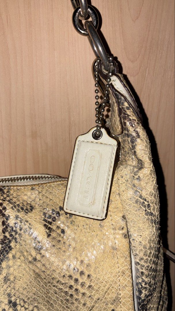 Coach Python Embossed Leather Hobo Shoulder Bag (Category: Luxury Bags & Wallets) located in Placer. Submitted by talaalond61563 (Listing ID 1464287929, Image 3). Description: - Authentic Coach hobo bag - Unique python embossed pattern - Cream leather trim and silver hardware - Stylish chain detail on the strap - Includes original Coach hangtag - Spacious interior for essentials - Ideal for everyday use.