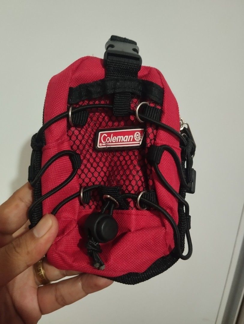 Coleman Mini Backpack Keychain Pouch Red (Category: Purses & Pouches) located in Candon. Submitted by bernabepradoiii (Listing ID 1464282804, Image 1). Description: - Compact red Coleman pouch - Features a carabiner clip for easy attachment - Buckle strap for secure closure - Mesh front pocket with bungee cord detail - Zipper closure for main compartment - Perfect for organizing keys, coins, or other small essentials - Great for camping trips or 