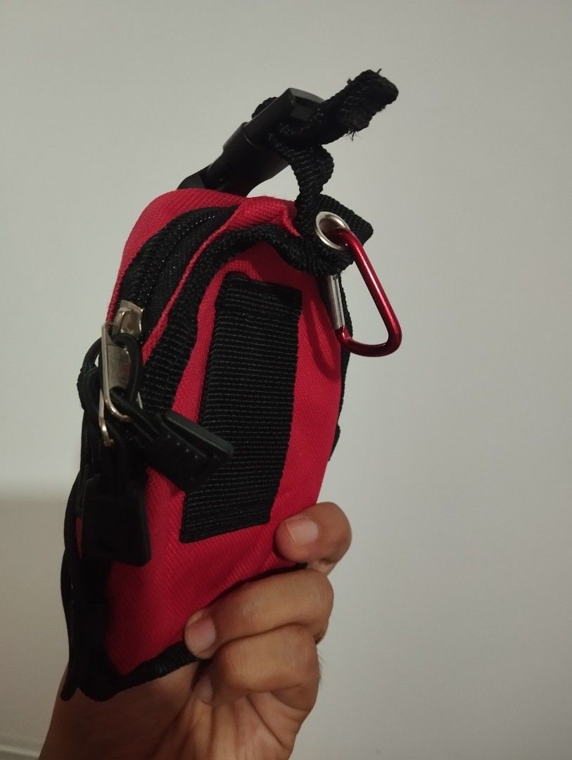 Coleman Mini Backpack Keychain Pouch Red (Category: Purses & Pouches) located in Candon. Submitted by bernabepradoiii (Listing ID 1464282804, Image 2). Description: - Compact red Coleman pouch - Features a carabiner clip for easy attachment - Buckle strap for secure closure - Mesh front pocket with bungee cord detail - Zipper closure for main compartment - Perfect for organizing keys, coins, or other small essentials - Great for camping trips or 