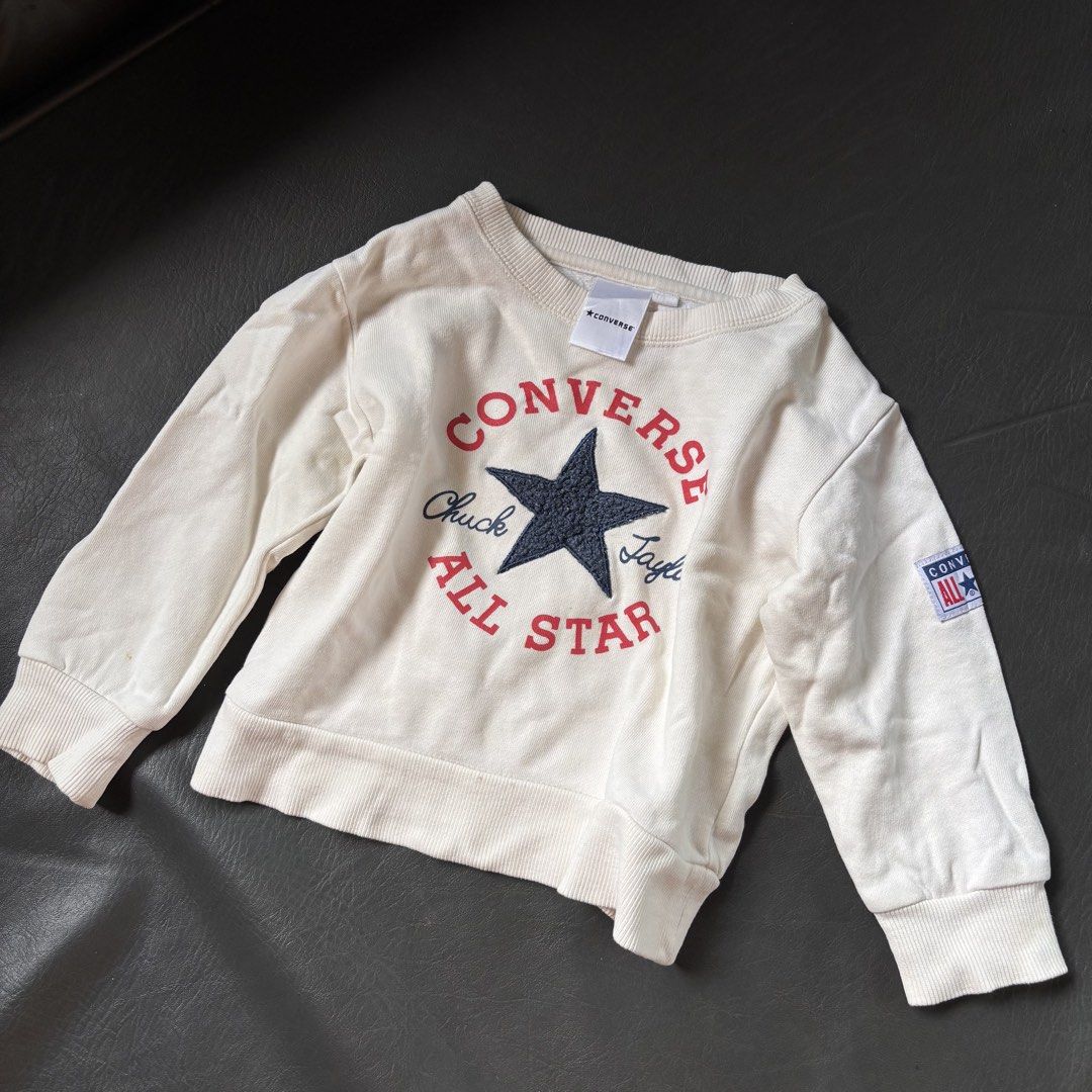 Converse Chuck Taylor Sweatshirt (Category: Babies & Kids Fashion) located in Mati. Submitted by sharieeng (Listing ID 1464148826, Image 1). Description: - Cream colored Converse sweatshirt - Features classic Chuck Taylor All Star logo on front - Small Converse patch on sleeve - Soft and cozy interior - Perfect for casual wear.
