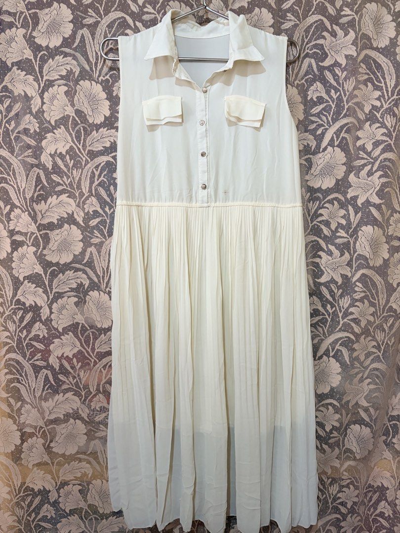 Cream Sleeveless Collared Pleated Midi Dress (Category: Dresses) located in Manila. Submitted by danielle.finds (Listing ID 1464190785, Image 1). Description: - Cream sleeveless dress - Collared neckline - Two chest pockets - Button-up front - Pleated midi skirt - Lightweight fabric - Perfect for casual outings or dressing up With washable stain.