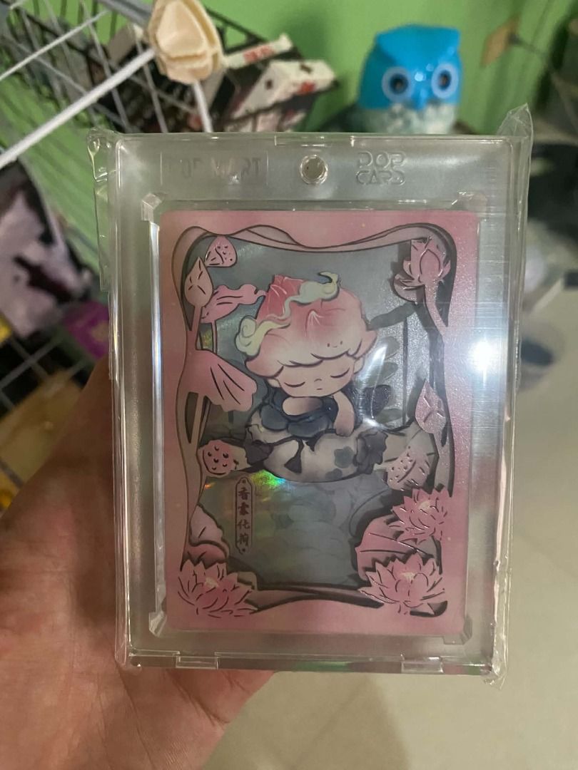 Dimoo Acrylic (Category: Raw Singles) located in Angeles City. Submitted by rickki_t (Listing ID 1464219461, Image 1). Description: - POP MART collectible card - Features a cute character with a lotus flower design - Eye-catching holographic effect - Comes in a protective case - Ideal for collectors and adding to your collection.