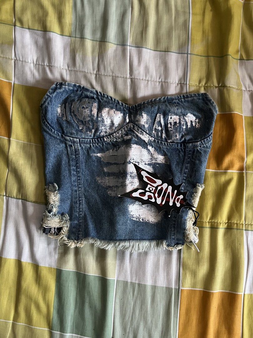 Distressed Denim Corset Top with Graphic Print (Category: Sleeveless) located in Manila. Submitted by thebeau.ph (Listing ID 1464222653, Image 1). Description: - Blue denim corset top - Distressed look with rips and frayed edges - White graphic print on the front - 'BONG' tag - Unique piece for a bold look - Great for parties or festivals.
