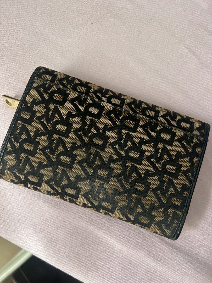 DKNY Monogram Wallet (Category: Wallets & Card holders) located in Quezon City. Submitted by vieee_ (Listing ID 1464243202, Image 2). Description: - Authentic DKNY wallet - Signature monogram pattern in black and tan - Multiple card slots for organization - Zippered compartment for coins or small items - Secure snap closure - Elegant gold-tone hardware - Perfect for keeping your essentials tidy.