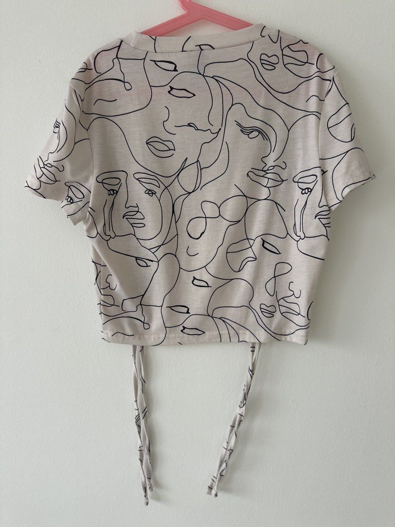 Drawstring Top (Category: Shirts) located in Singapore. Submitted by ayvnn (Listing ID 1464239685, Image 3). Description: - White graphic t-shirt - Unique abstract face print - Adjustable drawstring hem - Short sleeves - Crew neck - Ideal for casual wear - Pairs well with jeans or shorts ✅ +$2.50 for tracked mail via singpost OR buy with the ‘buy’ button for cheaper tracked mail ❌ no meetups/ self collect ❌ no additional photos ❌ no negos/ trades