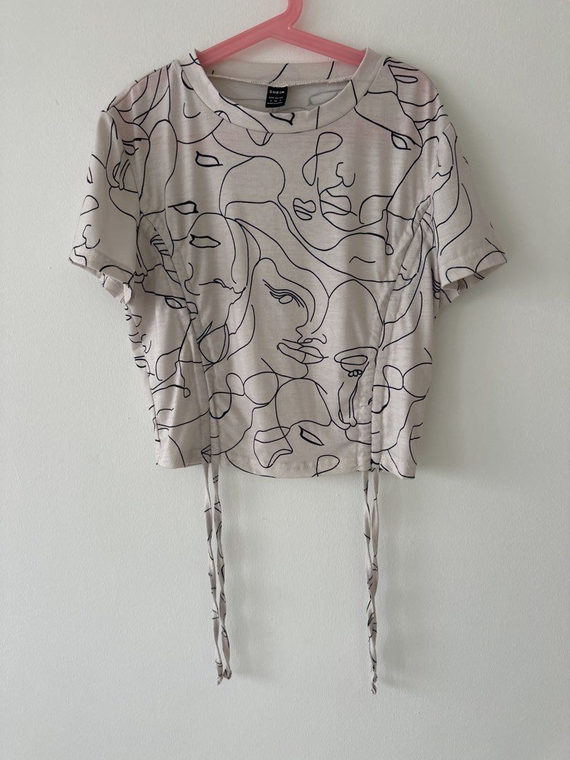 Drawstring Top (Category: Shirts) located in Singapore. Submitted by ayvnn (Listing ID 1464239685, Image 2). Description: - White graphic t-shirt - Unique abstract face print - Adjustable drawstring hem - Short sleeves - Crew neck - Ideal for casual wear - Pairs well with jeans or shorts ✅ +$2.50 for tracked mail via singpost OR buy with the ‘buy’ button for cheaper tracked mail ❌ no meetups/ self collect ❌ no additional photos ❌ no negos/ trades