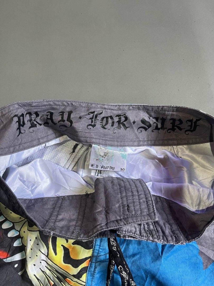 Ed Hardy Tiger & Logo Board Shorts (Category: Swim Trunks & Board Shorts) located in Panabo. Submitted by t-thrifts (Listing ID 1464186025, Image 3). Description: - Cool Ed Hardy board shorts - Features a bold tiger graphic and lettering - Elastic waistband with adjustable drawstring for a comfortable fit - Includes back pockets - Ideal for swimming, beach days, or casual lounging - Unique and eye-catching design.