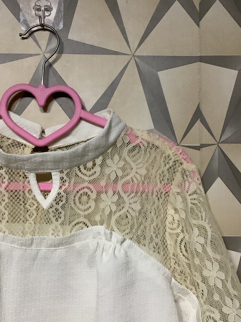 Elegant Lace-Panel Puff-Sleeve Blouse (Category: Blouses) located in Quezon City. Submitted by lovedbyerara (Listing ID 1464272314, Image 2). Description: Design Layout: It features a solid white opaque body panel juxtaposed with a sheer, floral-patterned lace yoke spanning across the upper chest, shoulders, and back. Neckline Detail: Designed with a mock-neck style collar, accented by a subtle teardrop keyhole cut-out at the center front. Sleeve