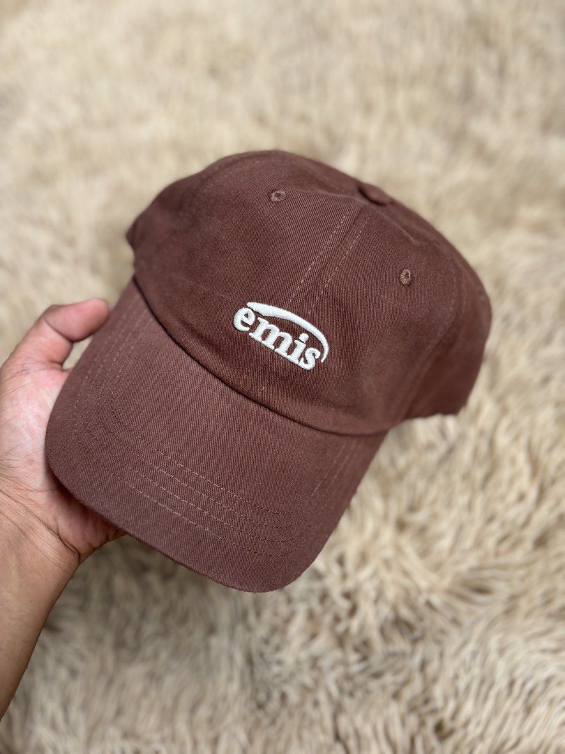 Emis Brown Baseball Cap (Category: Caps & Hats) located in Quezon City. Submitted by nojthrift (Listing ID 1464252192, Image 2). Description: - Brand: Emis - Color: Brown - Style: Baseball Cap - Features: Embroidered Emis logo on front - Material: 100% Cotton - Fit: Adjustable strap at the back - Ideal for: Everyday wear.
